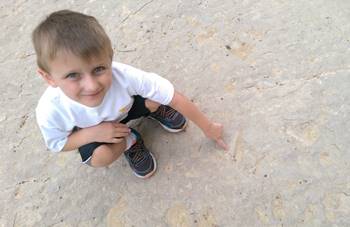 My son happy to have found one of the very clear tracks at the Red Gulch Dinosaur Tracksite, near Shell, WY.